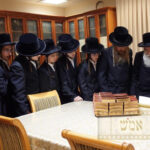 Recipient receiving a special siddur of recognition from the Belzer Rebbe Shlita