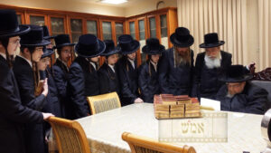 Recipient receiving a special siddur of recognition from the Belzer Rebbe Shlita