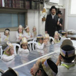 Kitta Aleph students receiving a new siddur from the Makover Rebbe Shlita